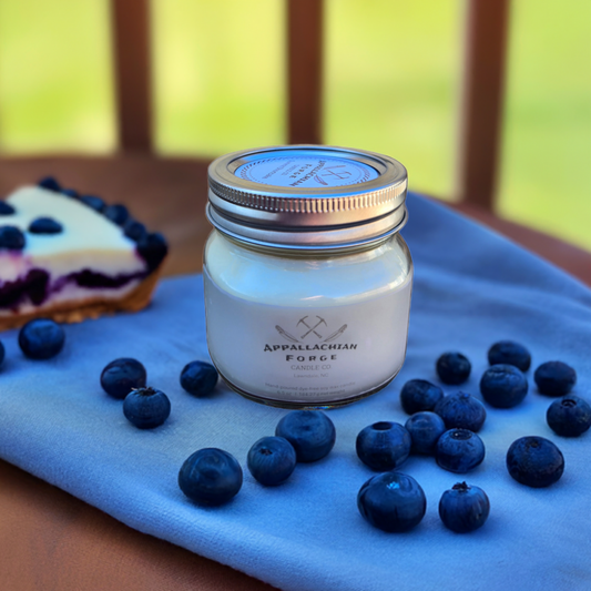 Nanny's Blueberry Pie hand-poured dye-free soy wax candle with fresh blueberries and blueberry pie slice on blue cloth