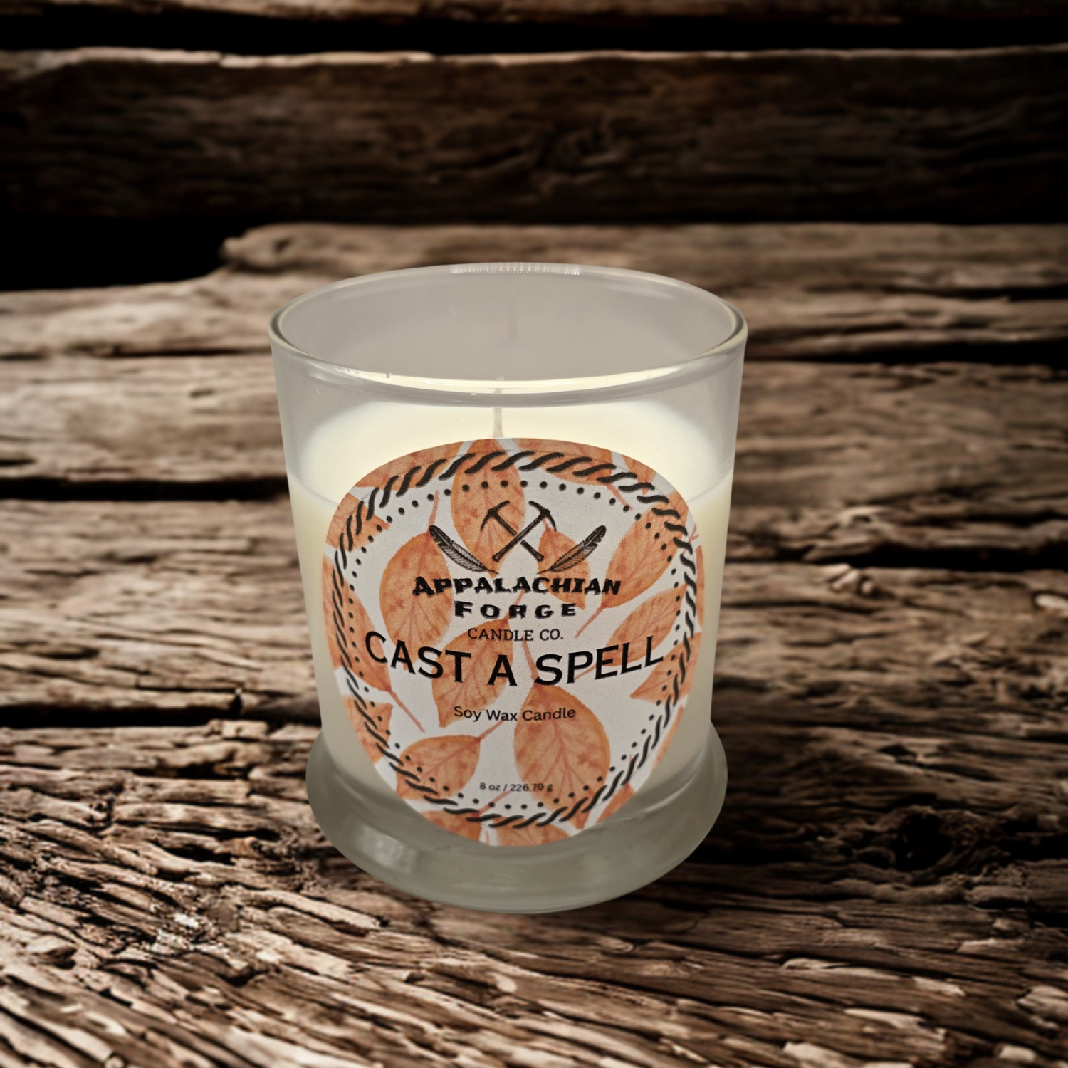 Cast A Spell dye-free soy wax candle in clear glass jar on rustic wooden surface