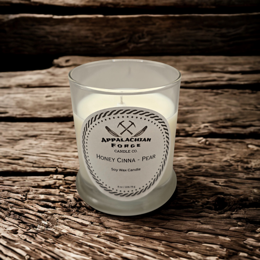 Honey Cinna Pear dye-free soy wax candle in clear glass jar on wooden surface