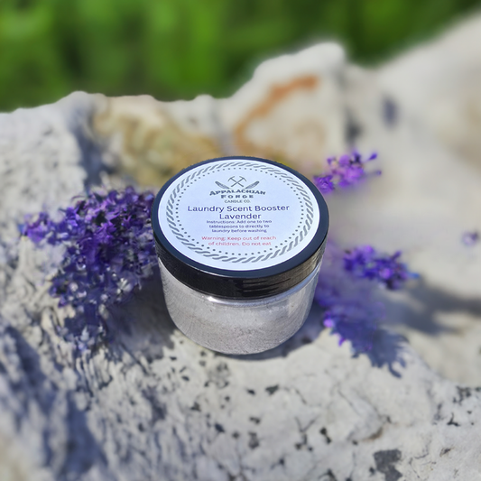 Lavender Fields Laundry Scent Booster jar with lavender flowers in a natural setting.